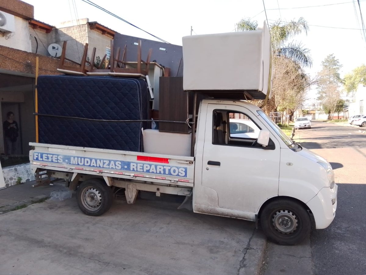 Camioneta con muebles, colchón y objetos grandes atados para un flete o mudanza.